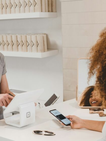 man in grey crew-neck t-shirt smiling to woman on counter